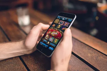 উৎসবের মুহূর্তে ঐতিহ্যবাহী পোশাক পরা এক আনন্দিত নারী তার স্মার্টফোন ব্যবহার করছেন, যা দেখায় 777BED অ্যাপ কীভাবে দৈনন্দিন জীবনের সঙ্গে সহজে মানিয়ে যায়।